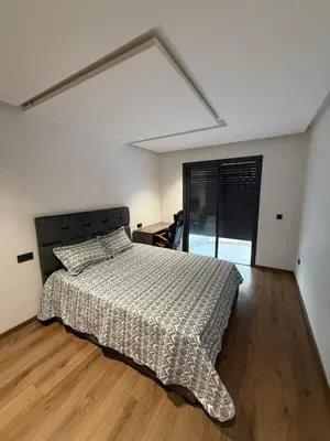 a bedroom with a bed and a large window at Appartement maarif in Casablanca