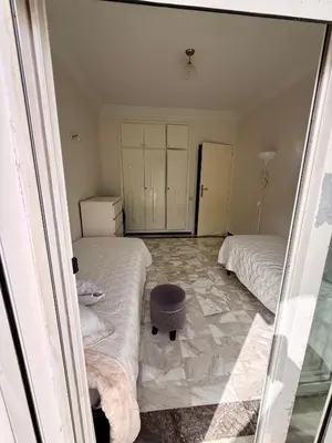 a bedroom with two beds and a ottoman on the floor at Luxury Apartment Ocean View and Private Beach Ain Diab in Casablanca