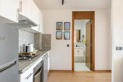 a kitchen with white cabinets and a counter top at Au Petit Port Balcony & Sea view 5 mn from casa-port in Casablanca