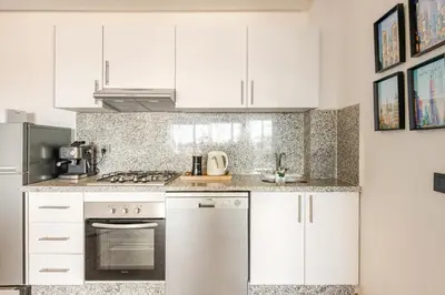 a kitchen with white cabinets and a stove top oven at Au Petit Port Balcony & Sea view 5 mn from casa-port in Casablanca