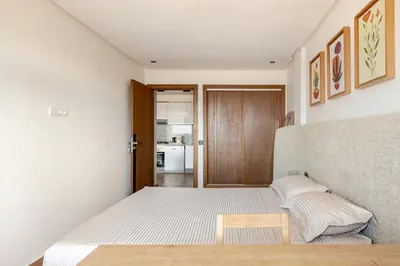 a small bedroom with a bed and a table at Au Petit Port Balcony & Sea view 5 mn from casa-port in Casablanca