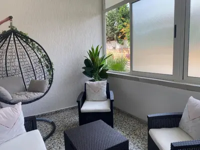 a room with chairs and a swing and a window at Duplex - Pool and Beach in Dar Hamida