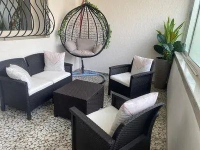 a patio with chairs and a table and a mirror at Duplex - Pool and Beach in Dar Hamida
