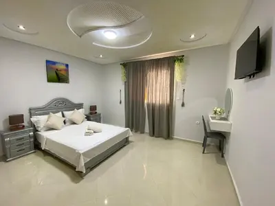a bedroom with a bed and a desk and a television at Duplex - Pool and Beach in Dar Hamida