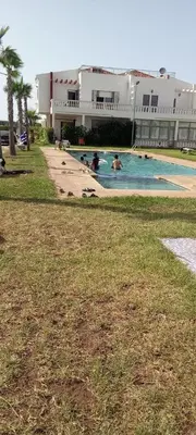 a swimming pool in a building with people in it at Duplex - Pool and Beach in Dar Hamida