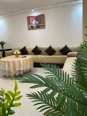 a living room with a couch and a table at Duplex - Pool and Beach in Dar Hamida
