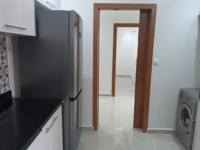 a kitchen with a refrigerator and a laundry room at Appartement 3 chambres et Salon sans ascenseur 3 mn à pied au Parc du Mohammedia in Mohammedia