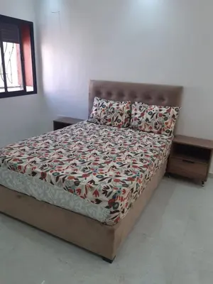 a bed in a white room with a bed sidx sidx sidx at Appartement 3 chambres et Salon sans ascenseur 3 mn à pied au Parc du Mohammedia in Mohammedia