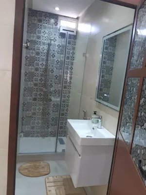 a bathroom with a sink and a shower at Appartement 3 chambres et Salon sans ascenseur 3 mn à pied au Parc du Mohammedia in Mohammedia