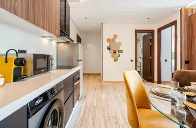 a kitchen with a table and a dining room at Studio vert chic au cœur de Casablanca in Casablanca