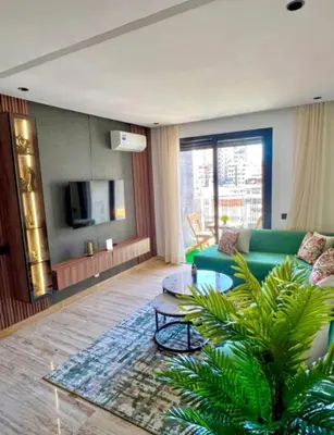 a living room with a green couch and a table at Studio vert chic au cœur de Casablanca in Casablanca