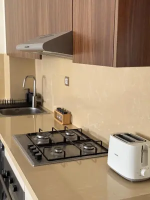 a kitchen with a stove and a toaster on a counter at Appartement moderne avec piscine, 2 chambres in Bouznika