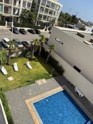 an overhead view of a swimming pool next to a building at Appartement moderne avec piscine, 2 chambres in Bouznika