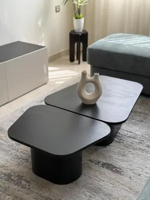 a black coffee table with a vase on top of it at Appartement moderne avec piscine, 2 chambres in Bouznika