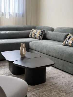a living room with a couch and a vase on a table at Appartement moderne avec piscine, 2 chambres in Bouznika