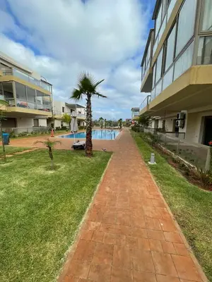 a brick walkway with a palm tree next to a building at Blue beach in Bir Jedíd Saint-Hubert