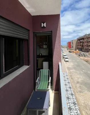 a green and white chair sitting on the balcony of a building at apartment in sidi rahal in Sidi Rahal
