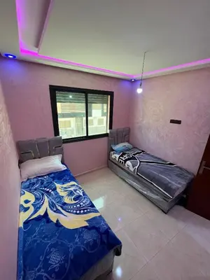 two beds in a room with a window at apartment in sidi rahal in Sidi Rahal