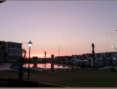 a sunset in a city with a street light and buildings at Dokkali