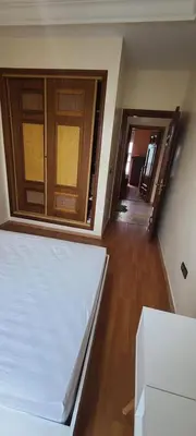 a room with a bed and wooden floors and doors at 2 bedrooms apt Ricoflores Mimosa in Mohammedia