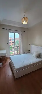 a bedroom with a bed and a desk and a window at 2 bedrooms apt Ricoflores Mimosa in Mohammedia