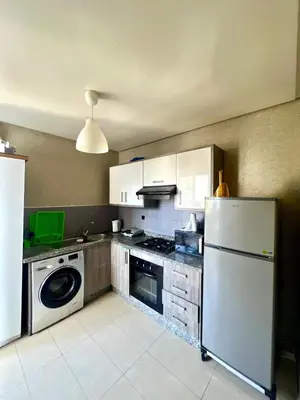 a kitchen with a white refrigerator and a dishwasher at Appt moderne 3 chbr Blanca Beach in Sidi Rahal