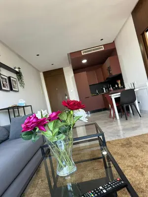 a vase of flowers sitting on a glass table in a living room at Charming Studio in Oasis in Oulad Akkou