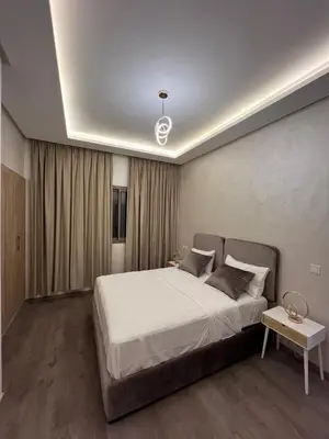 a bedroom with a large white bed and a table at Zenata tower in Casablanca