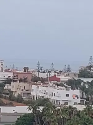 a group of houses on a hill near the ocean at اجمل شقة in Temara