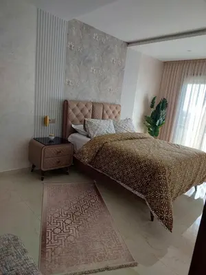 a bedroom with a large bed and a night stand at اجمل شقة in Temara