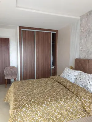a bedroom with a large bed with a gold bedspread at اجمل شقة in Temara