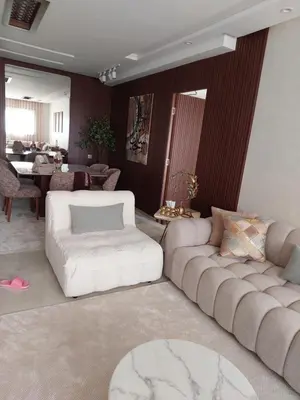 a living room with two couches and a table at اجمل شقة in Temara