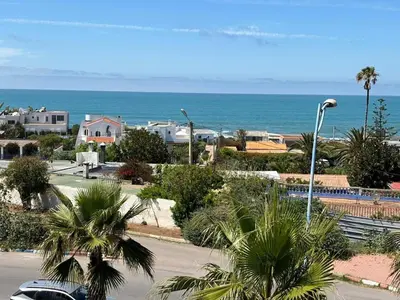 a view of a street with palm trees and the ocean at Luxury Sea View in Tamaris