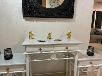 a white dresser with a clock on the wall at Luxury Sea View in Tamaris