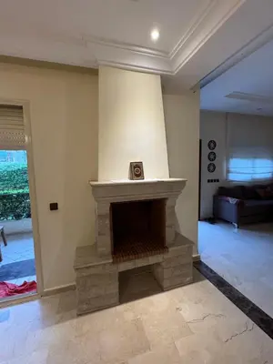 a living room with a stone fireplace in a house at Savannah beach in Dar Hamida