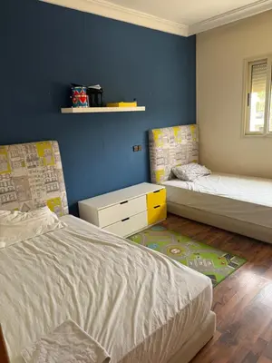 a bedroom with two beds and a blue wall at Savannah beach in Dar Hamida