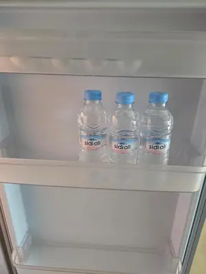 four bottles of water with blue caps sitting in a refrigerator at Le CasaStud' in Casablanca