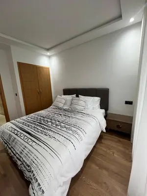 a bedroom with a large bed with white sheets and pillows at Magnifique appartement 2 chambres vue sur piscine - Sidi Rahal in Sidi Rahal
