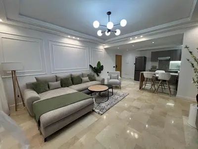 a living room with a couch and a table at Magnifique appartement 2 chambres vue sur piscine - Sidi Rahal in Sidi Rahal