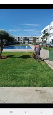 a man is pulling a suitcase in a park at Mansouria in Mohammedia