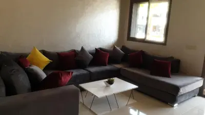 a living room with a couch with colorful pillows at Mansouria in Mohammedia