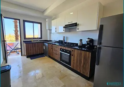 a kitchen with a stainless steel refrigerator and wooden cabinets at Le Refuge Océanique idéal ! in O Ben Slimane