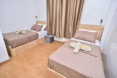 a small bedroom with two beds and curtains at Appartement Authentique & Moderne au Cœur de la Médina in Casablanca