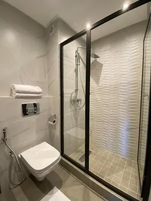a bathroom with a shower with a toilet and a glass shower stall at M'ocean Sea View Apartment by 7AV Hotels in Mohammedia