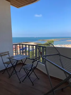 a balcony with two chairs and a table and the ocean at M'ocean Sea View Apartment by 7AV Hotels in Mohammedia
