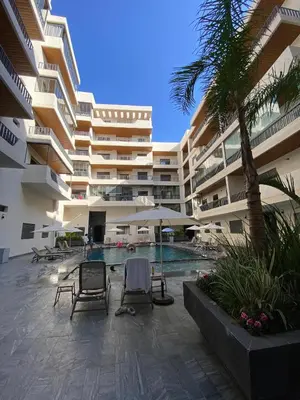 a large building with chairs and a swimming pool at M'ocean Sea View Apartment by 7AV Hotels in Mohammedia