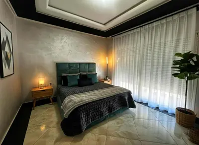 a bedroom with a bed and a large window at Luxury Villa with pool 6 min to Football Stadium CAF in Rabat