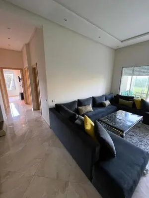 a living room with a blue couch and a table at Appartement casa bay sidi rahel in Sidi Rahal