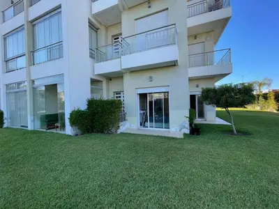 a large apartment building with a lawn in front of it at Appartement casa bay sidi rahel in Sidi Rahal