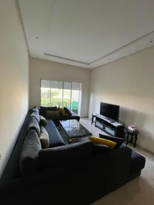 a living room with a black couch and a piano at Appartement casa bay sidi rahel in Sidi Rahal